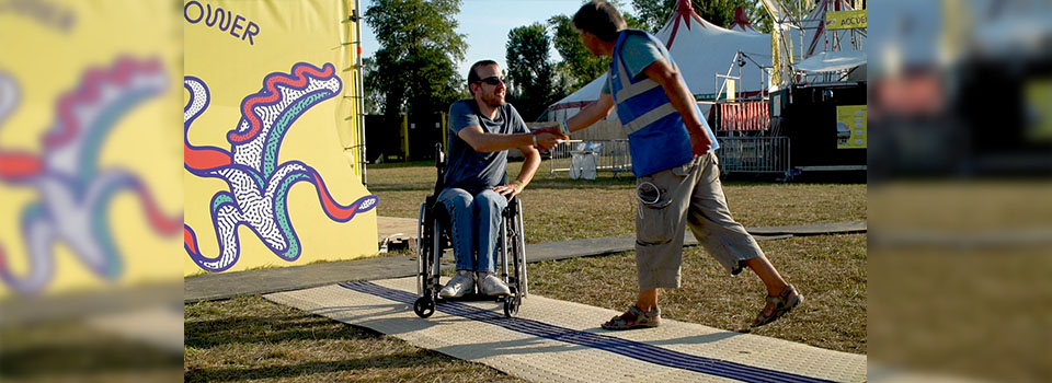 Test du CAU-mobility d’une personne en fauteuil roulant au festival Woodstower 2019 Test du CAU-mobility d’une personne en fauteuil roulant, le testeur serre la main de Rui Pereira