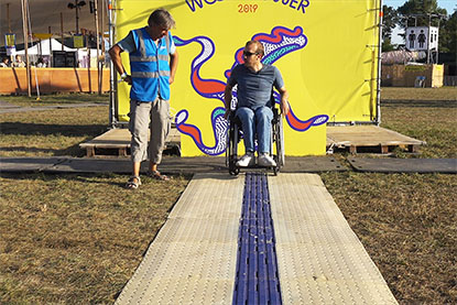 Test au festival Woodstower Une personne en fauteuil roulant manuel teste le CAU-mobility installé sur l’herbe